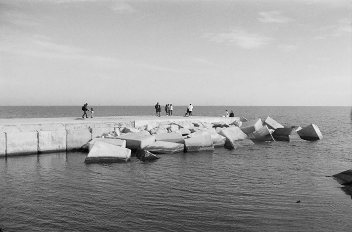 Black and white photograph of a jetty with people on it