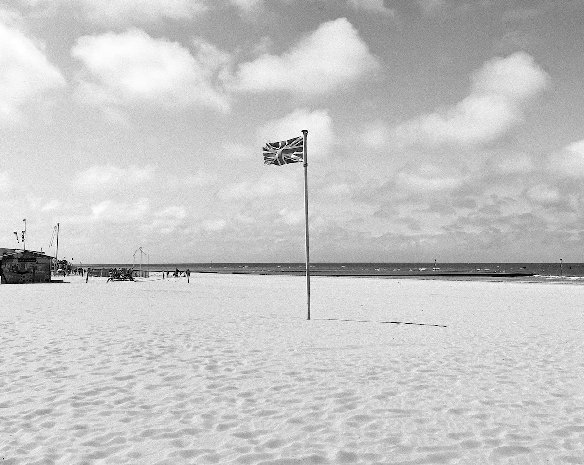 Photograph of union jack flag on a beach with small grain added