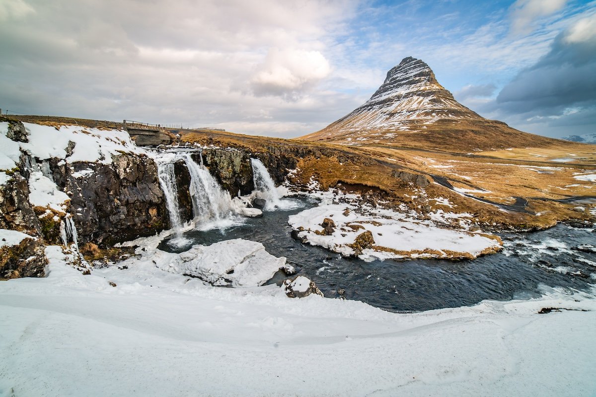 photo of a waterfall and mountain in a partly snowy scene edited in lightroom