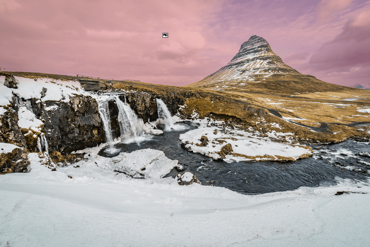 photo of a waterfall and mountain in a partly snowy scene with a sky mask applied in lightroom