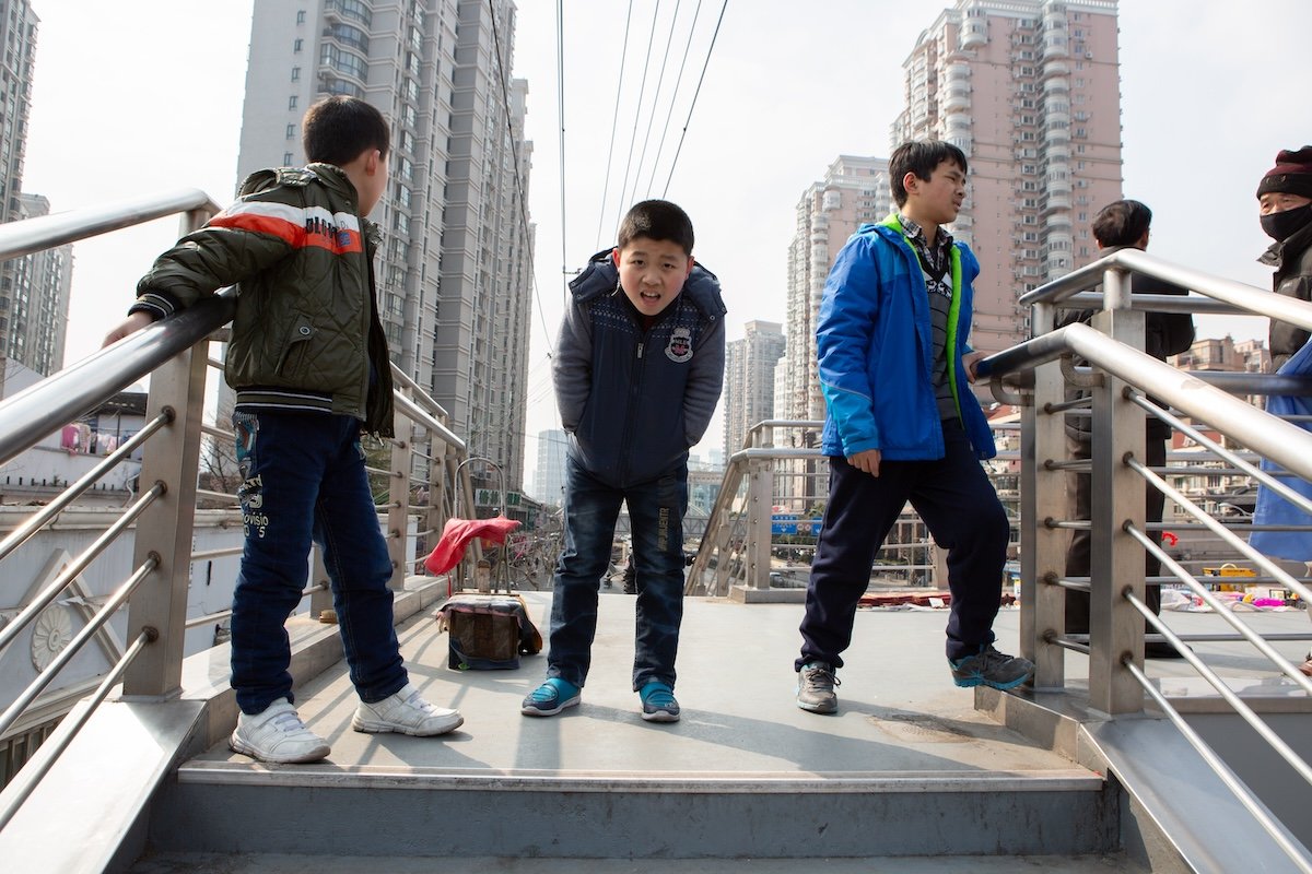 photograph of three kids on a bridge