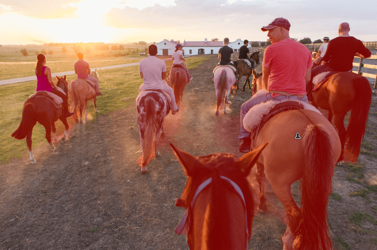 photo of a group on horses with the people and their horses masked in lightroom