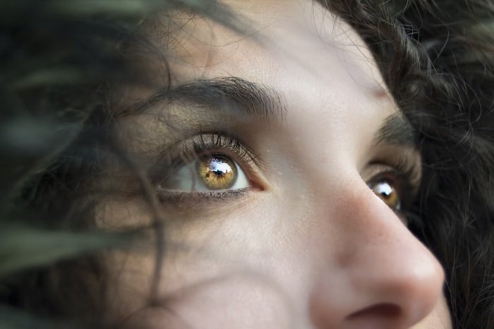 Close-up portrait of a woman's light brown eyes. 