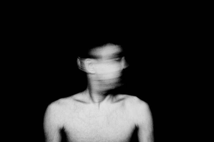 Surreal portrait of man with blurred face and head