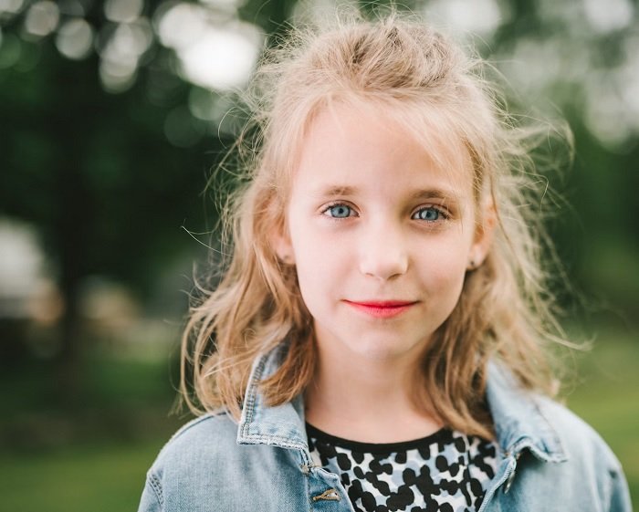 Portrait of young blond girl using shallow depth of field