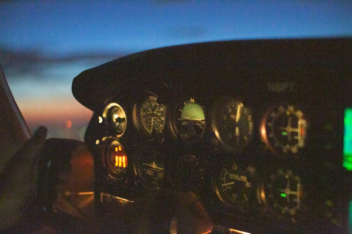 noisy photograph of a cockpit of a plane at night