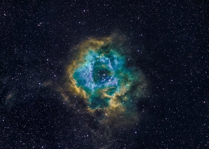 Blue and green nebula surrounded by stars as an example of astrophotography