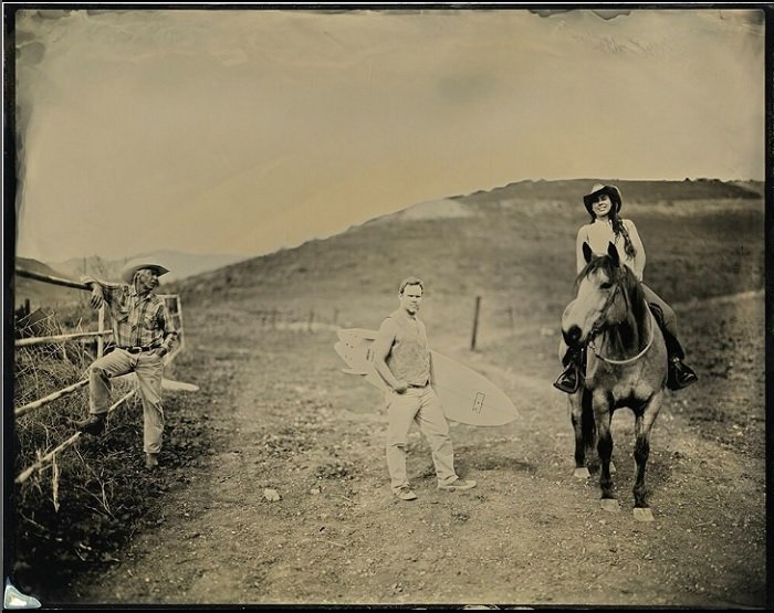 Wet plate image of cowboy leaning on a fence, man holding a surfboard, and a woman on a horse