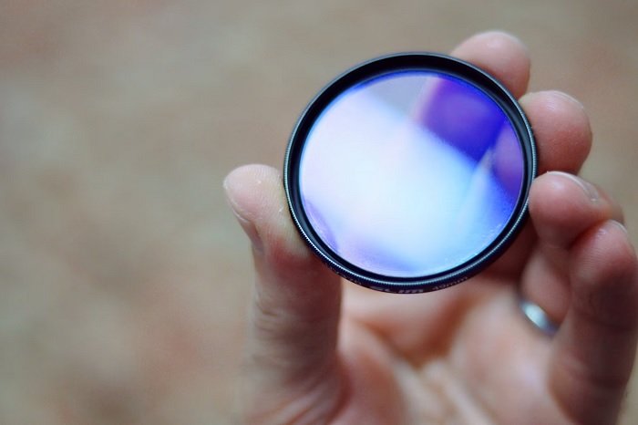 Hand holding a circular lens filter
