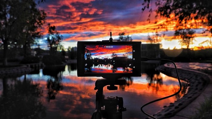 Smartphone mounted on a tripod in front of a sunset