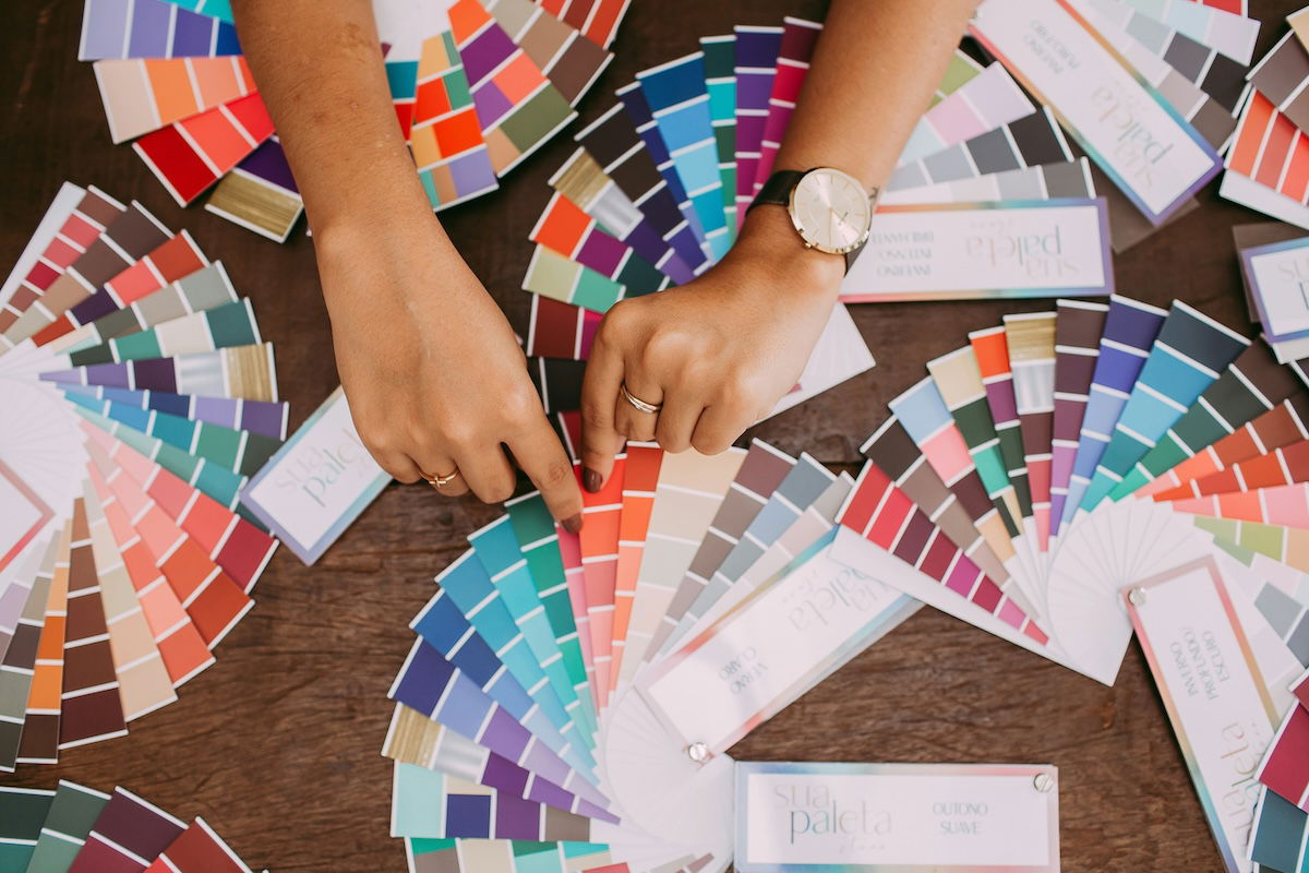 color swatches on a table with hands above them