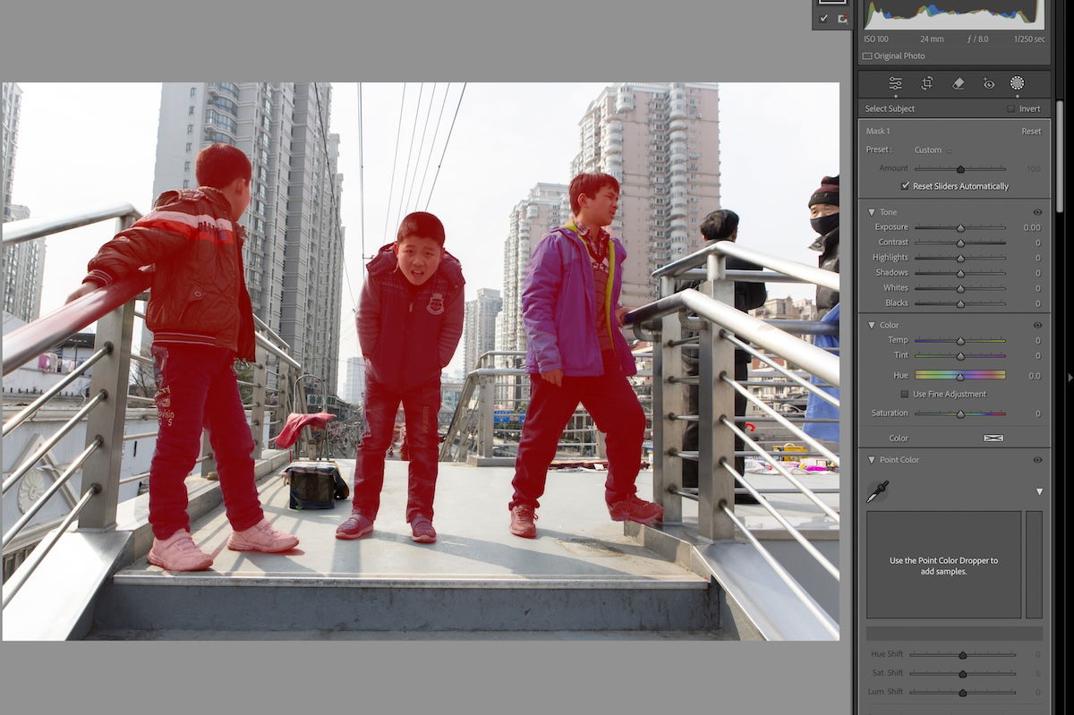 photograph of three boys on a bridge with red mask on figures