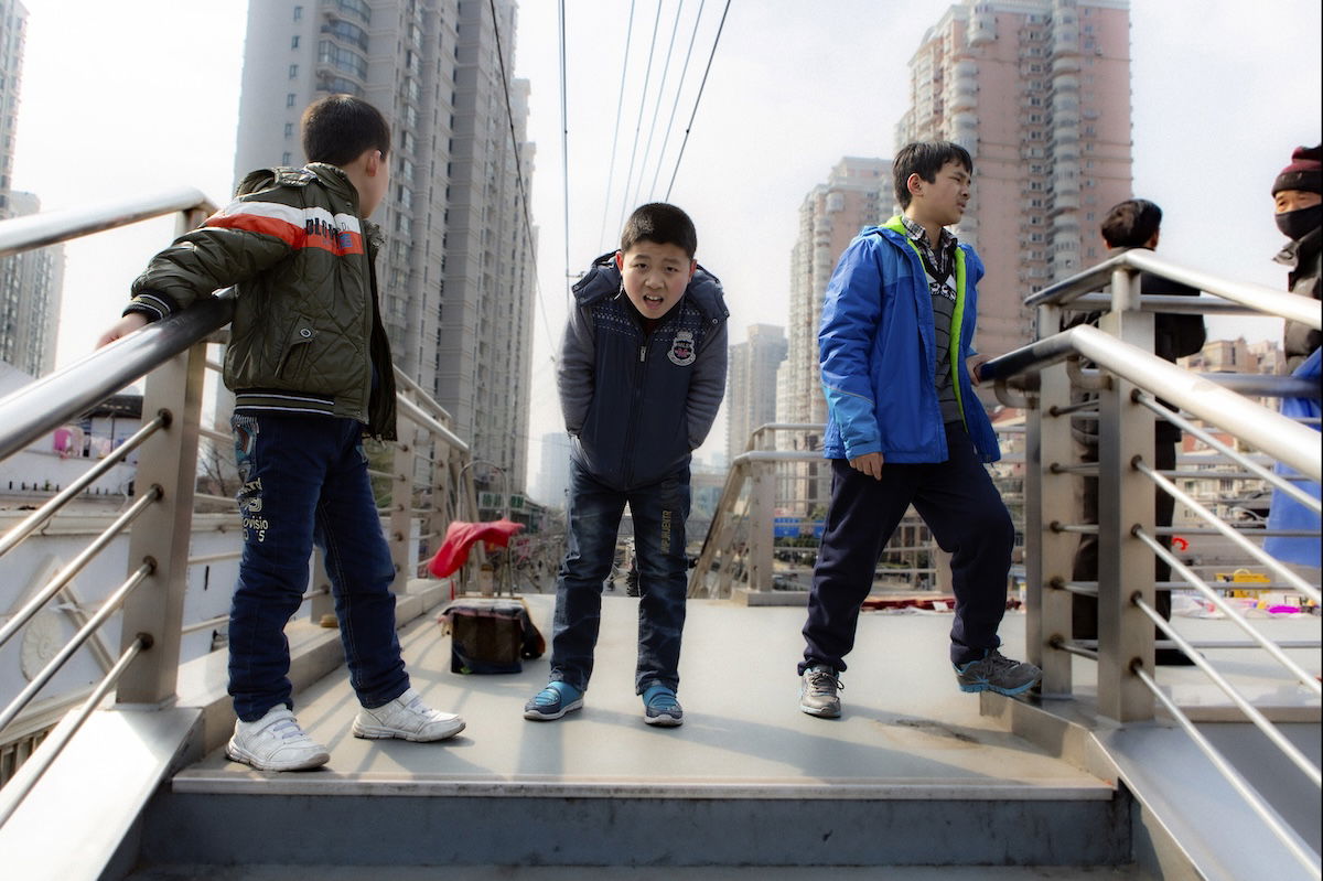 photograph of three boys on a bridge with background blurred