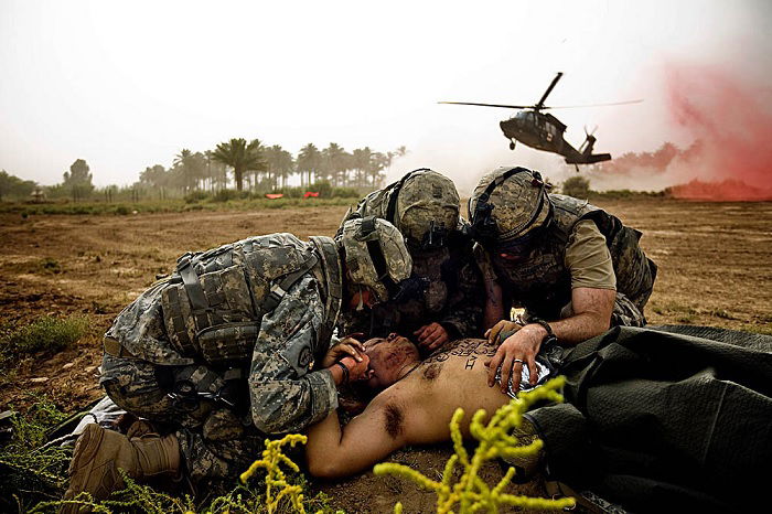 Three soldiers attend to wounded man