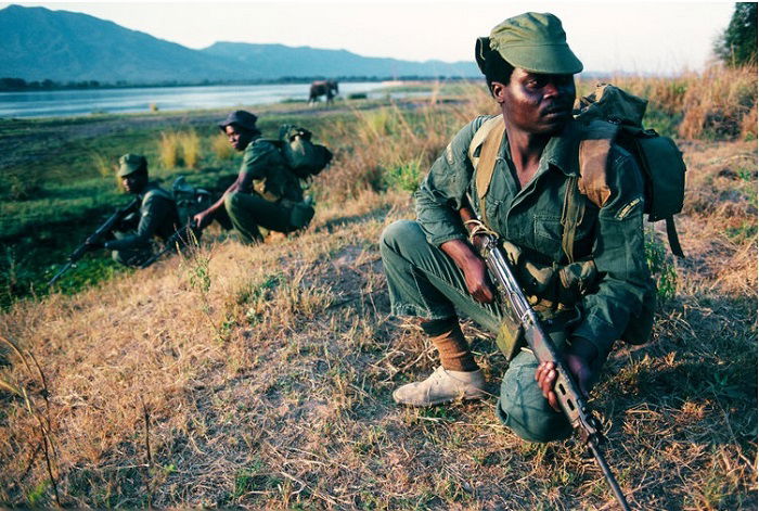 Man crouching down holding AK47