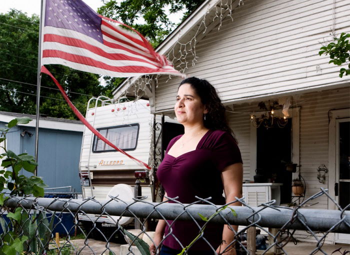 Woman standing in yard next to USA flag