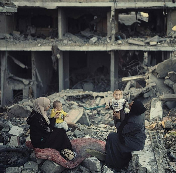 Two mothers with babies in bombed building