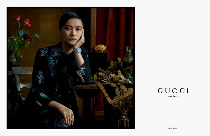 Gucci ad with woman sitting on chair with chin resting on hand