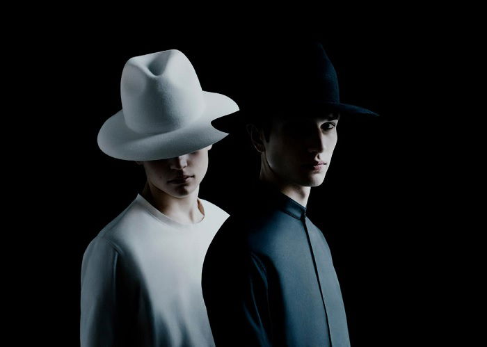 Two male models, one dressed in white the other in black