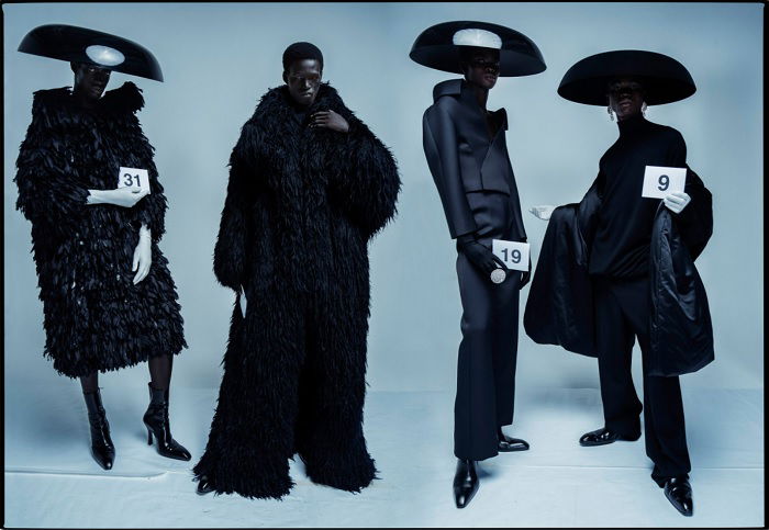 Four models dressed in strange black clothes