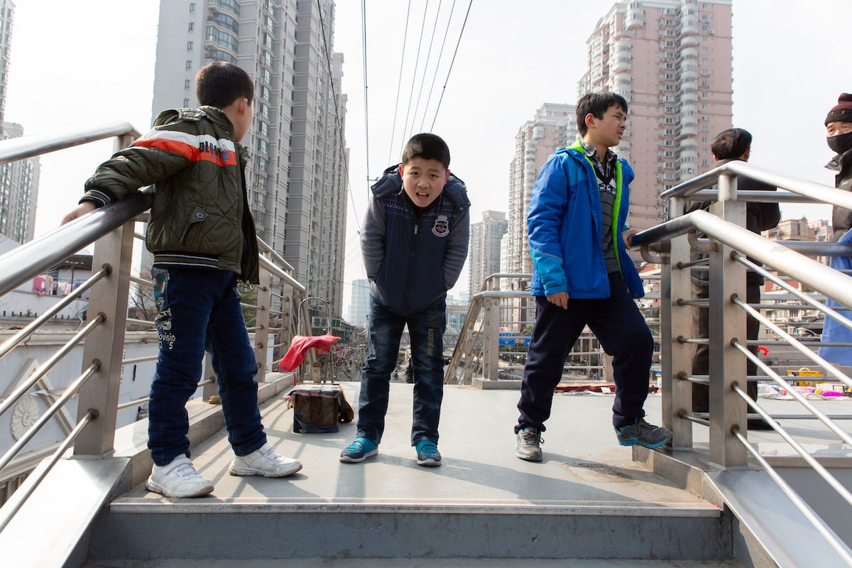 photograph of boys on a bridge in a city with added distortion