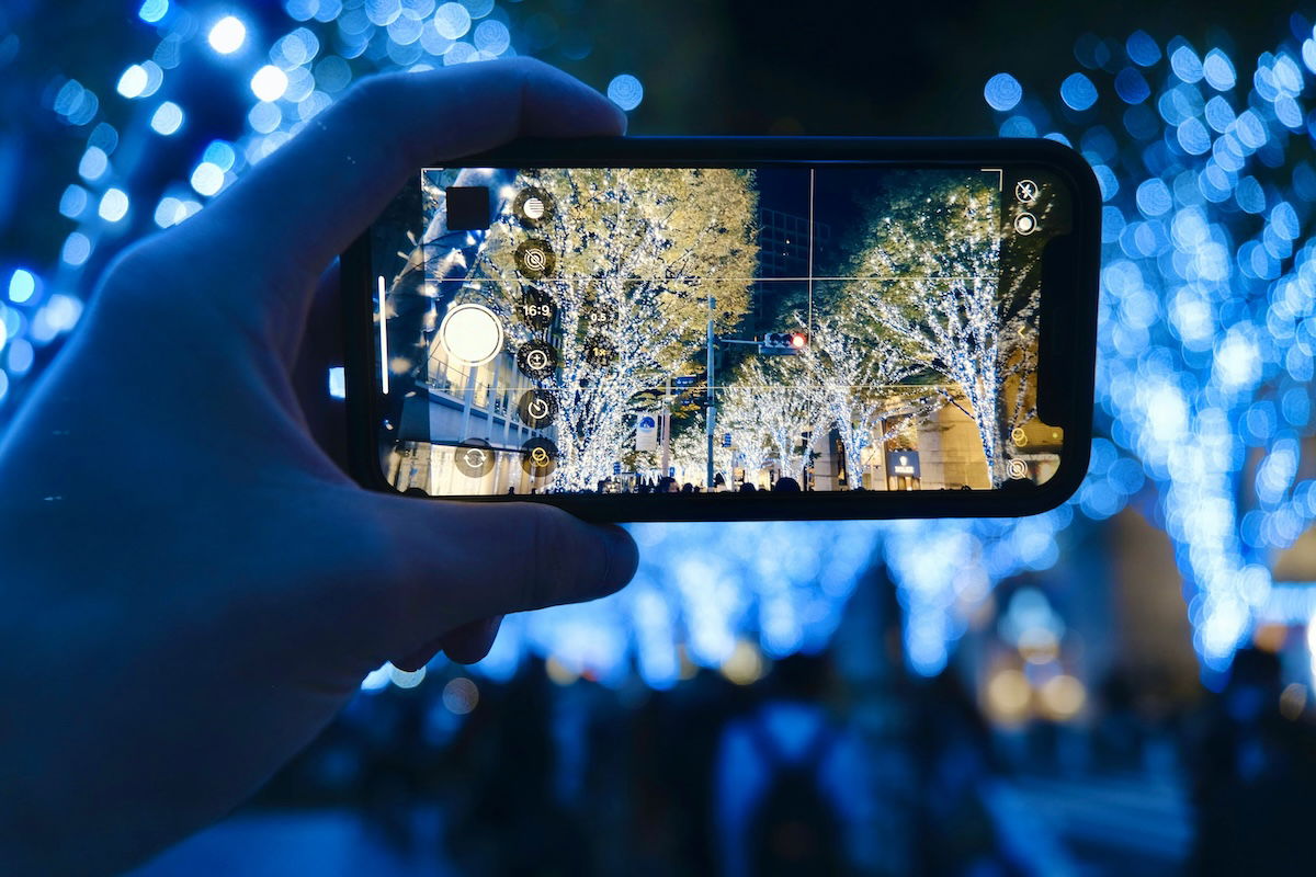 photograph of a camera taking a picture of blue lights in a tree