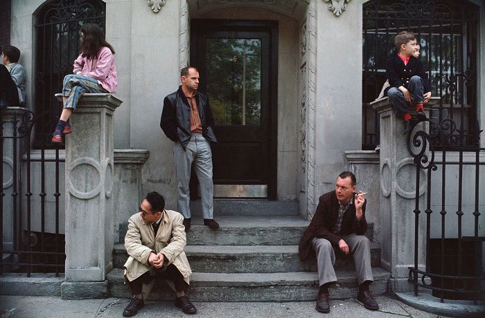 Five people waiting on street steps