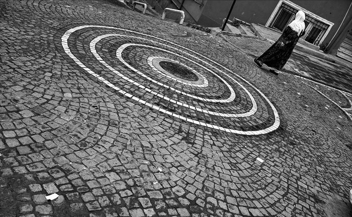 Woman walking pass circular pattern on the ground