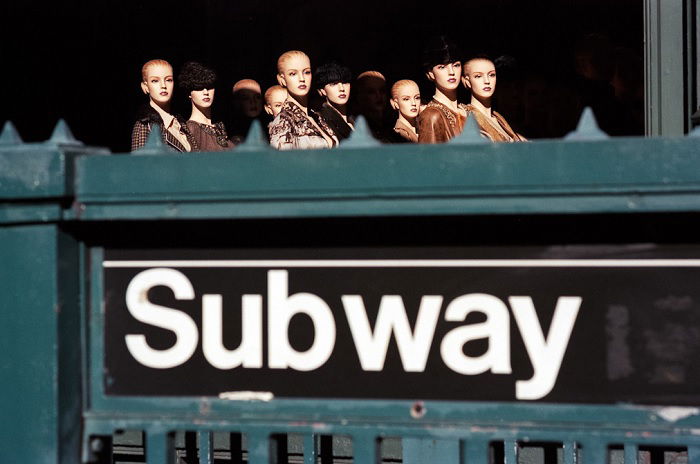 Mannequins behind a subway sign