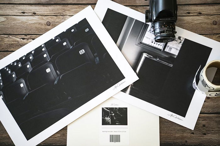 Overhead shot of two photography prints with camera on a table