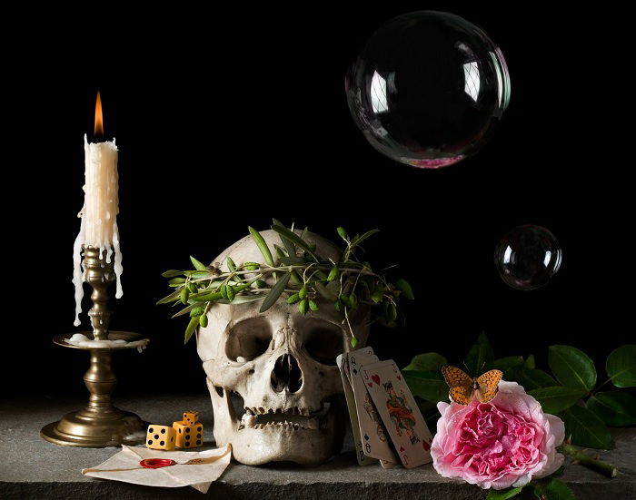 Still life of skull with headdress, candle, and bubble