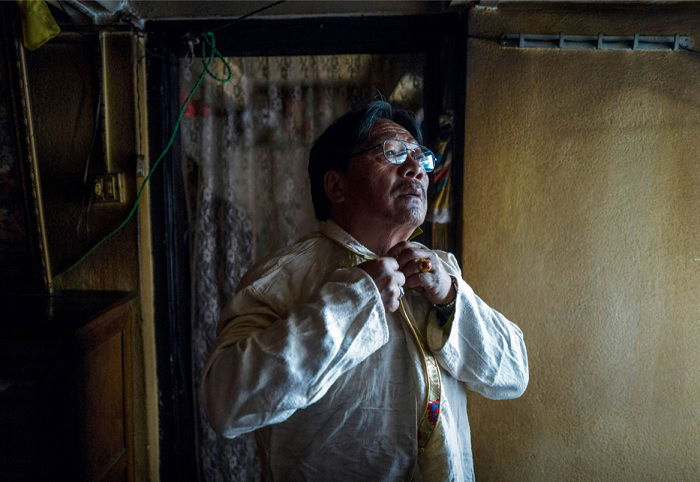 Elderly man putting on tie