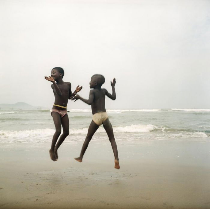 Two young boys jumping on a beach