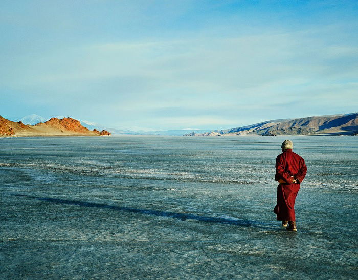 Mongolian monk walking on open ice plane