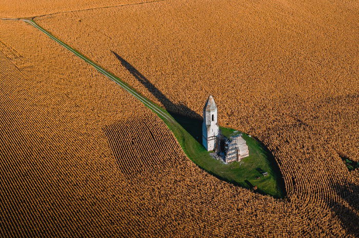 Aerial shot of small castle in a wheat field