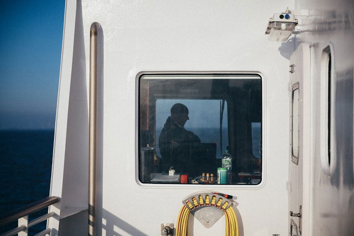 Sailor seen through ship window