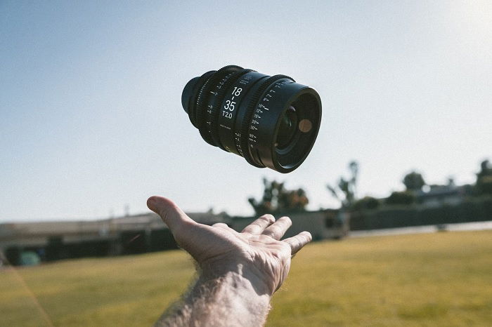 Hand catching falling video lens with t-stop values on barrel