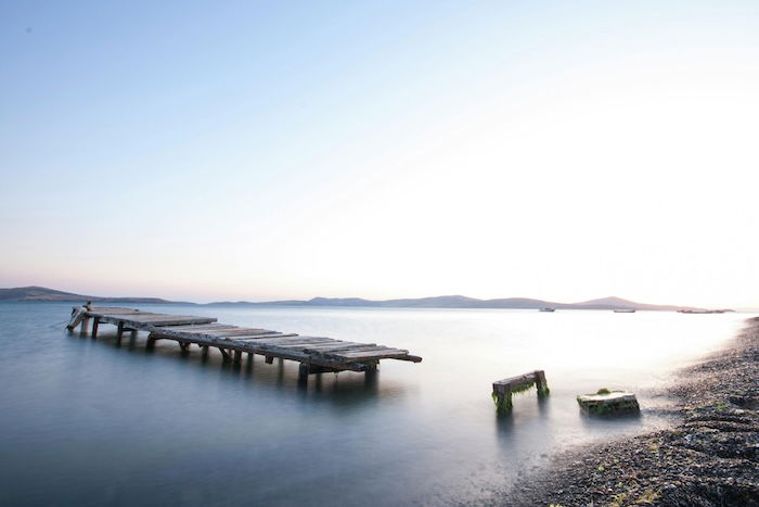 a broken pier with misty water surrounding it