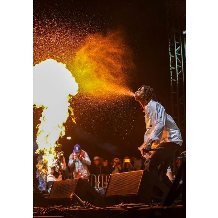 Male performer spitting a cloud of water in front of fire