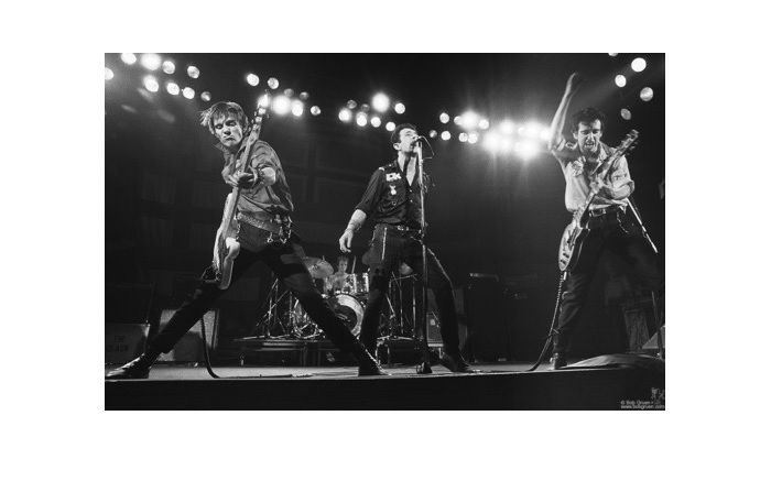 Three members of the Clash performing on stage