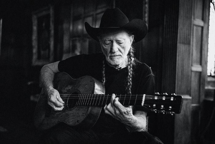 Portrait of Willy Nelson Playing the guitar