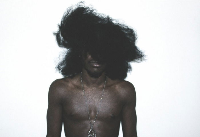 Portrait of Jesse Boykins with hair over his eyes