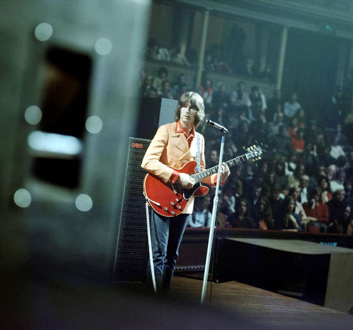 Eric Clapton on stage with red guitar