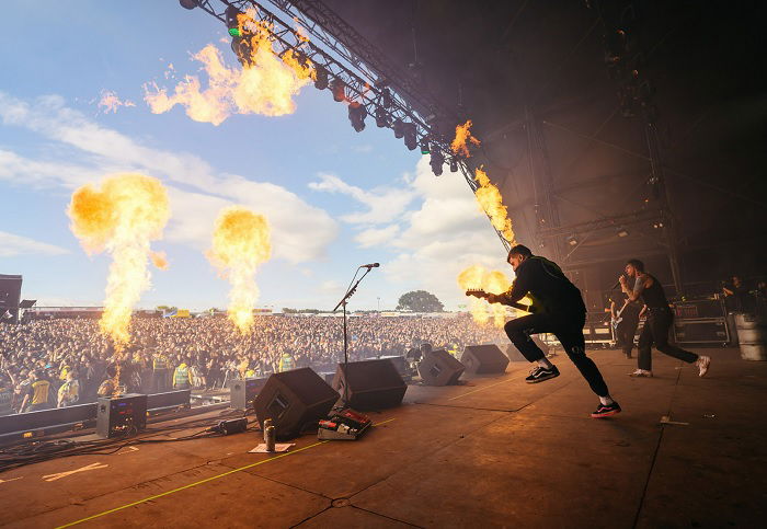 Band performing on stage with flames