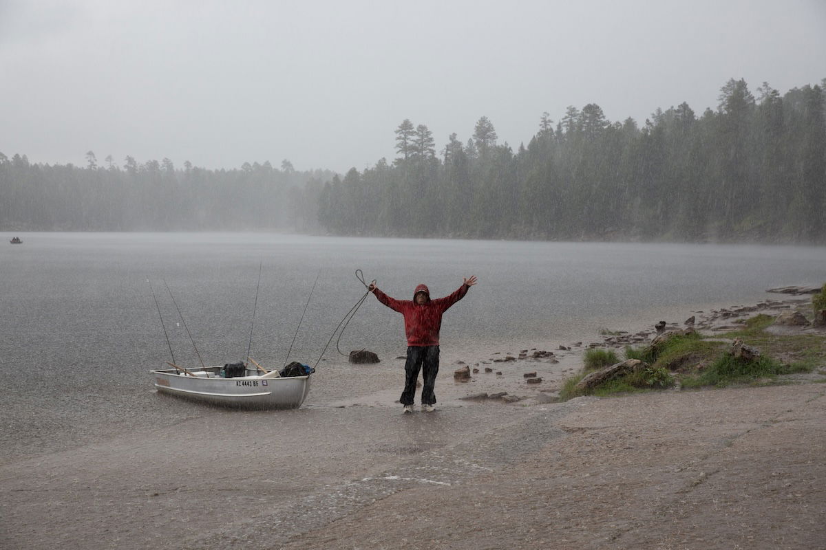 image of man in rain by a lake