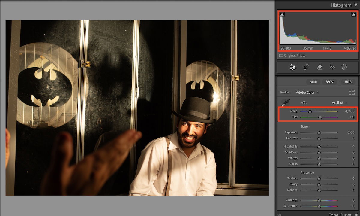 image of man on stage with bowler hat with highlighted temp and tint sliders and histogram in lightroom