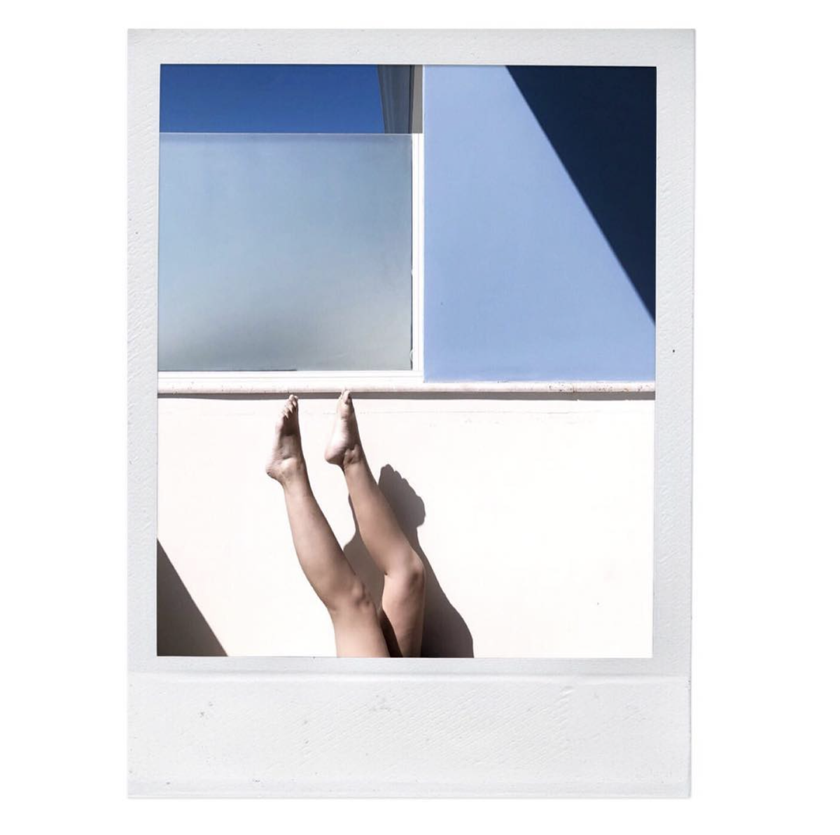 polaroid of womans legs in front of window