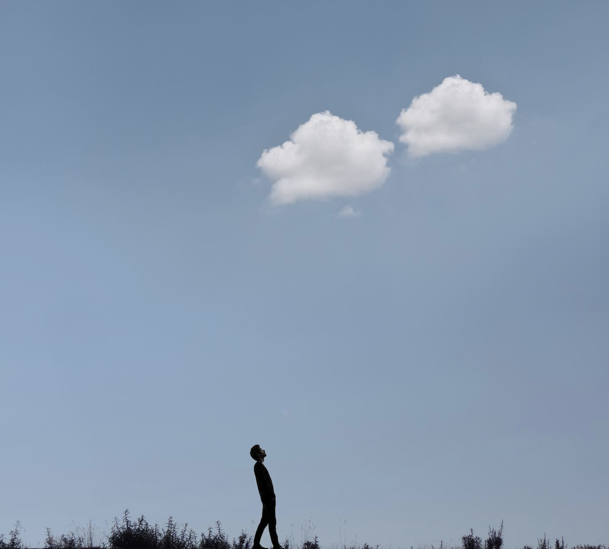 man looking up at clouds